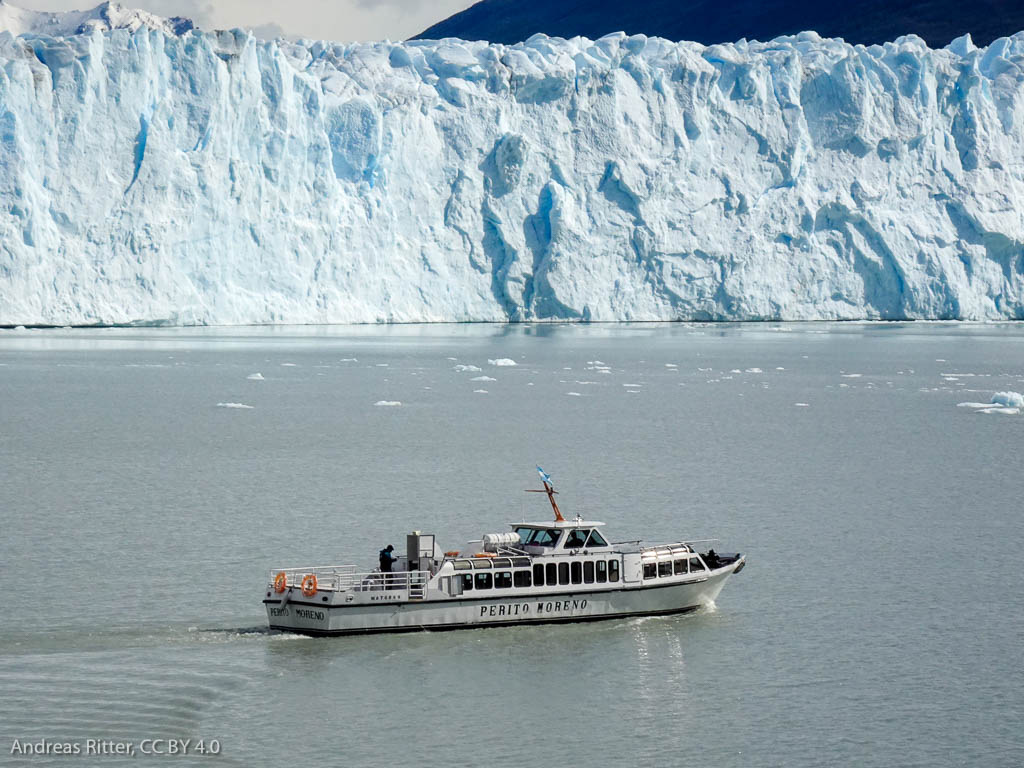 glaciar and a lake with a boat